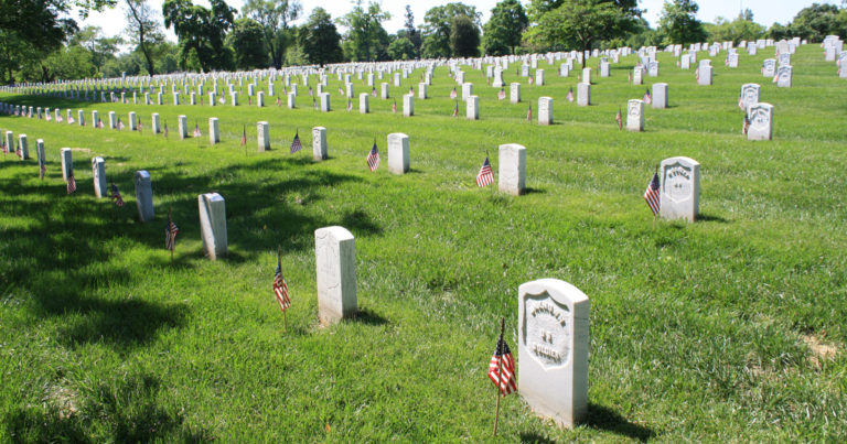 Who places the flags at Arlington National Cemetery gravesites for Memorial Day?